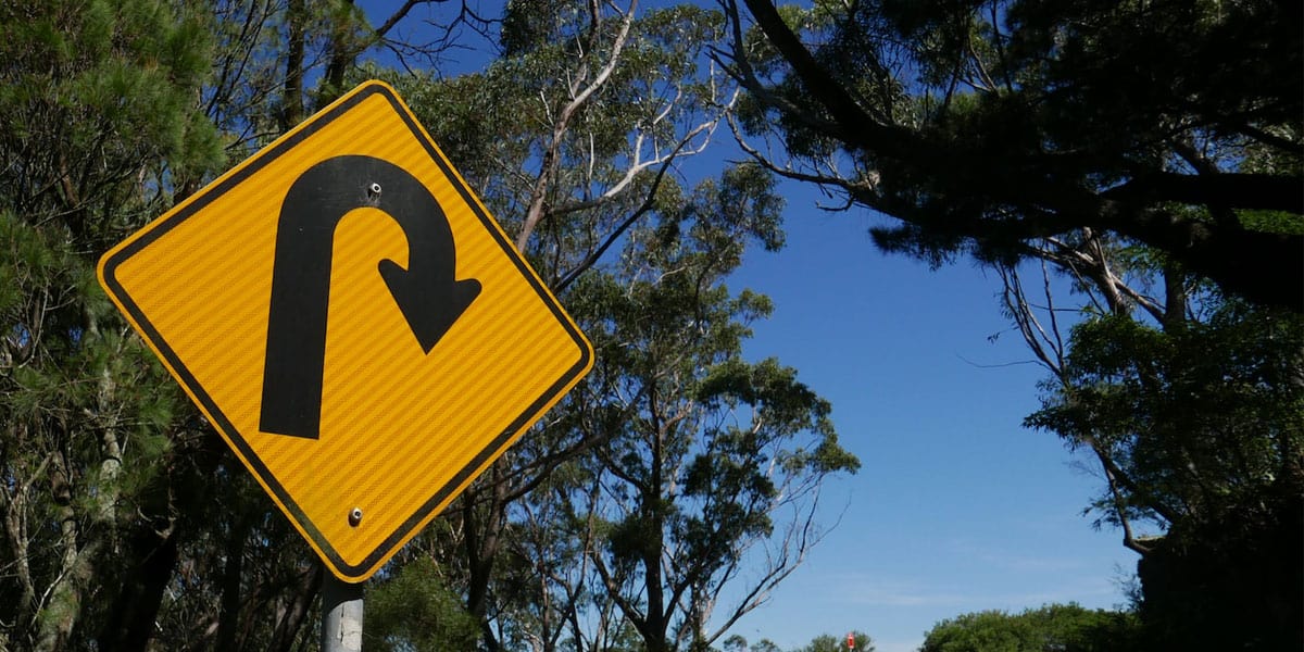 Yellow U-turn road sign